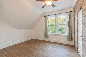 Third bedroom lofted ceiling, ceiling fan, and wood floors