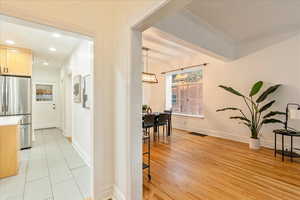 Corridor featuring ornamental molding and light tile patterned floors