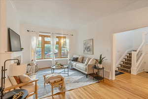 Living room featuring ornamental molding and light hardwood / wood-style floors