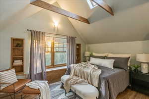 Bedroom featuring wood-type flooring and lofted ceiling with skylight