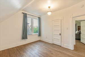 Second bedroom with lofted ceiling and wood floor.