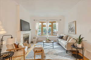 Living room with ornamental molding and wood-type flooring