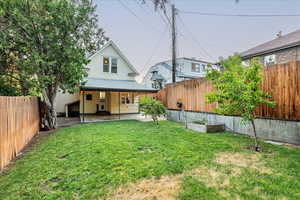 Rear view of property with a yard