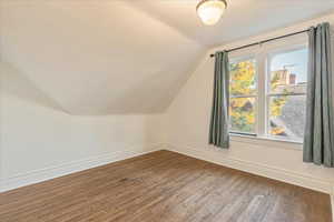 Second bedroom with wood flooring and lofted ceiling