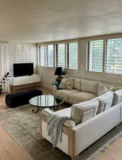 Living room with a textured ceiling and light wood-type flooring