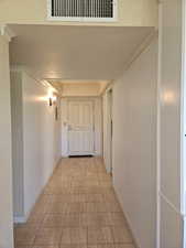 Hall featuring ornamental molding, a textured ceiling, and light tile patterned floors