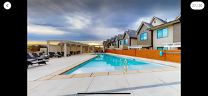 Pool at dusk featuring a patio area and a pergola