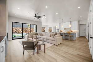 Living room with ceiling fan, light hardwood / wood-style flooring, and a textured ceiling