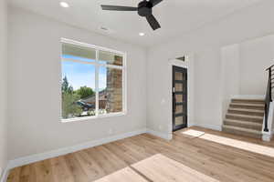 Empty room with light hardwood / wood-style flooring and ceiling fan