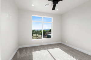 Carpeted empty room with ceiling fan