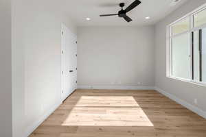 Unfurnished bedroom with ceiling fan and light wood-type flooring