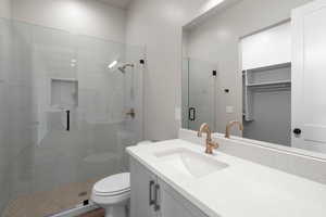 Bathroom featuring vanity, toilet, and an enclosed shower