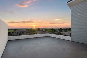 Patio terrace at dusk featuring a balcony