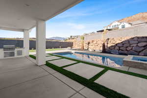 View of patio / terrace featuring grilling area, area for grilling, a mountain view, and a fenced in pool