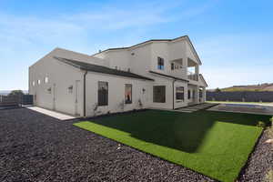 Back of property featuring a balcony, a patio, a fenced in pool, and a yard