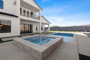 View of swimming pool featuring a patio and an in ground hot tub