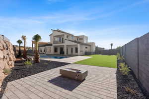 Rear view of house featuring a patio, a balcony, a yard, a fenced in pool, and a fire pit