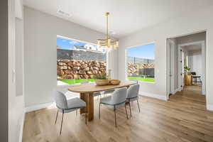 Dining area with a notable chandelier and light wood-type flooring