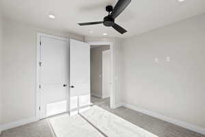 Unfurnished bedroom featuring ceiling fan and light carpet