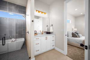 Bathroom featuring tile patterned floors, plus walk in shower, and vanity