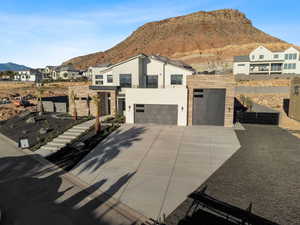 View of front of home with a mountain view and a garage