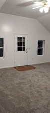 Interior space with carpet floors, ceiling fan, and lofted ceiling