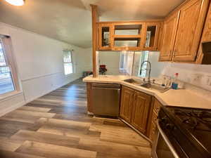 Kitchen featuring sink, dishwasher, stove, light hardwood / wood-style flooring, and kitchen peninsula