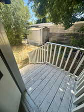 Wooden terrace featuring a shed