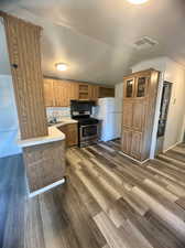 Kitchen with gas stove, white refrigerator, hardwood / wood-style floors, and sink