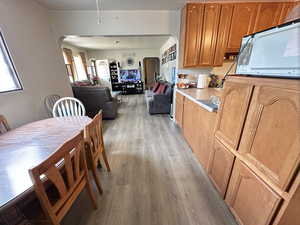 Kitchen with a textured ceiling, light hardwood / wood-style flooring, and a healthy amount of sunlight