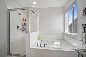 Bathroom featuring plus walk in shower and vanity