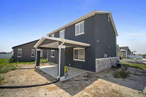 View of front of home featuring cooling unit and a patio