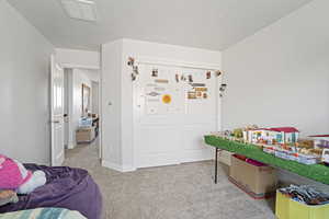 Bedroom with light carpet and a textured ceiling