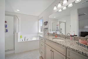 Bathroom with vanity, tile patterned floors, and shower with separate bathtub