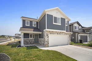 View of front facade featuring a garage and a front yard