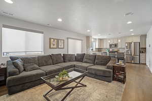 Living room featuring light hardwood / wood-style floors and a textured ceiling