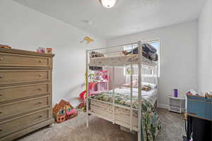 Carpeted bedroom featuring a textured ceiling