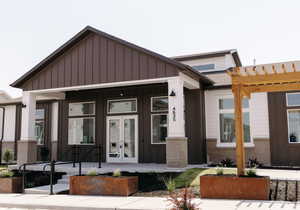 View of front facade featuring a pergola and french doors