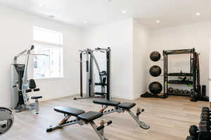 Exercise area with light hardwood / wood-style flooring