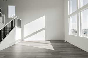 Interior space with dark hardwood / wood-style flooring and a high ceiling