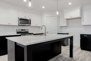 Kitchen featuring sink, a kitchen island with sink, and appliances with stainless steel finishes