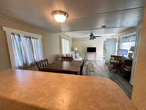 Dining area with dark hardwood / wood-style floors, ceiling fan, and a textured ceiling