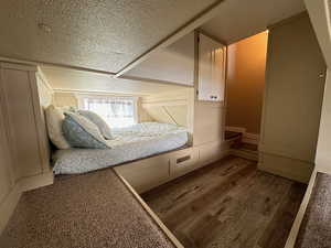 Unfurnished bedroom with a textured ceiling and wood-type flooring