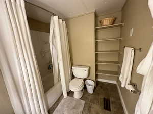 Bathroom with toilet, tile patterned floors, and shower / bathtub combination with curtain