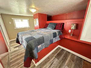 Bedroom with wood-type flooring and a textured ceiling