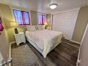 Bedroom with dark hardwood / wood-style floors, a closet, and ornamental molding