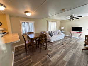 Dining room with a textured ceiling, hardwood / wood-style floors, and ceiling fan