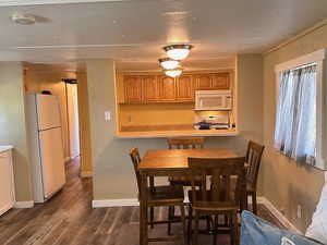 Dining room with dark hardwood / wood-style flooring and a textured ceiling