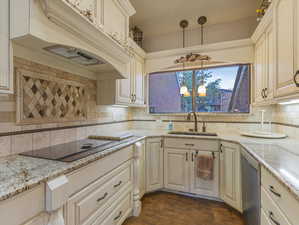 Kitchen with black electric cooktop, backsplash, dishwasher, dark wood-type flooring, and sink