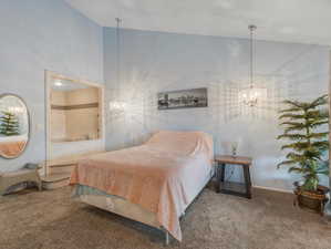 Bedroom with an inviting chandelier, carpet flooring, and high vaulted ceiling